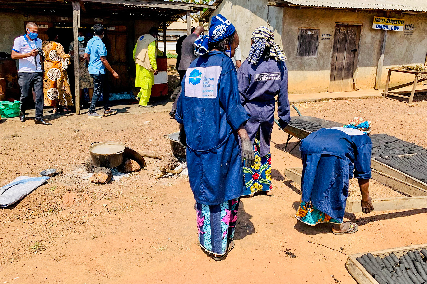 Women proudly display the final product of their hard work. The bio charcoal has been dried in the sun and is ready for the market.