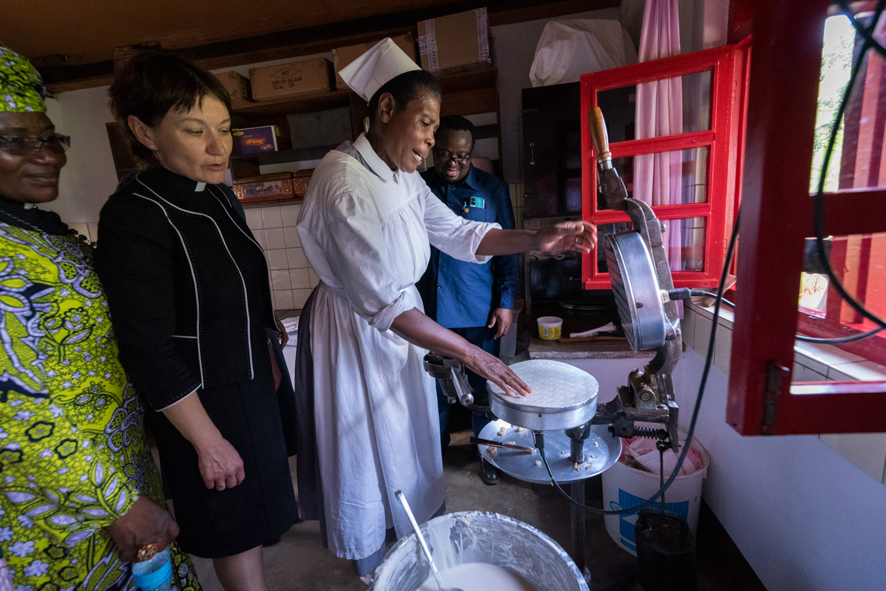 Sister Ufoolwakwe Kimaro — a former nurse-midwife now living and serving at the Ushirika wa Neema, Lutheran Sisters’ Convent of the Evangelical Lutheran Church in Tanzania — explains how she makes wafers for Holy Communion to LWF General Secretary Rev. Anne Burghardt, LWF Vice-President for Africa Rev. Dr Jeannette Ada Maina, and ELCT General Secretary Eng. Robert Kitundu.