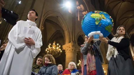 Youth hold symbols of creation during an ecumenical celebration at the Cathredral of Notre Dame de Paris during the COP 21 climate talks taking place in nearby Le Bourget, 3 December 2015 Photo: LWF/Ryan Rodrick Beiler