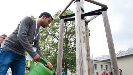 LWF Global Young Reformers Network member planting a tree at the Luther Garden in Wittenberg, Germany