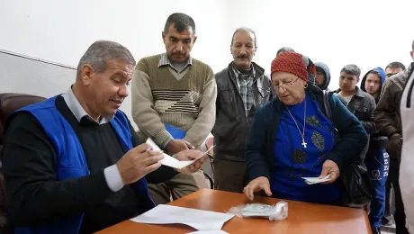 Gorgya Paols, 63, receives a LWF food voucher, entitling her to a carton of food that will last a month. Despite the violence she fled in 2005 and the worsening situation since the ISIS insurgency, her single wish is for peace in Iraq. Photo: LWF/S. Cox