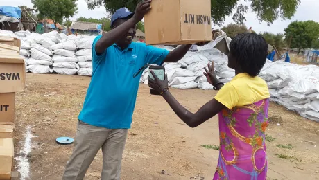 LWF staff provides a displaced woman in Bor with a water, sanitation and health kit. Photo: LWF/South Sudan