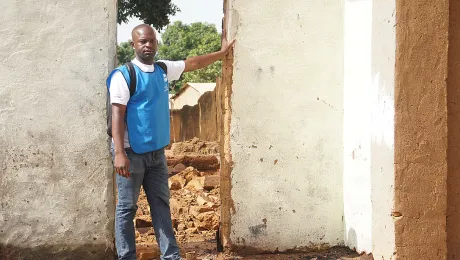 Armand Yabinti, community outreach officer for the LWF emergency program in CAR, outside the ruins of his house in Bohong village, Ouham PendÃ© prefecture.  Photo: LWF/P. Mumia