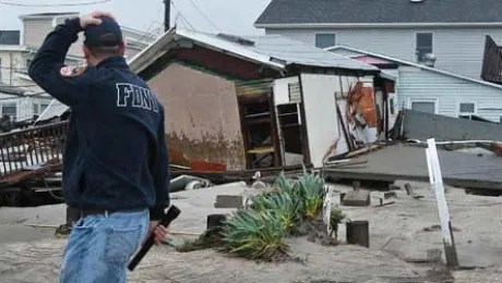 A man holds his head walking by homes in the Queens borough of New York, USA, devastated by Hurricane Sandy. Â© REUTERS/Shannon Stapleton, courtesy <a href=