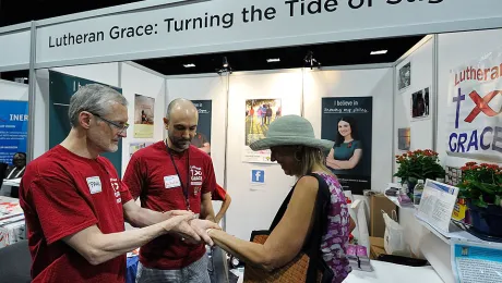 Volunteers offer a visitor a temporary tattoo at the 