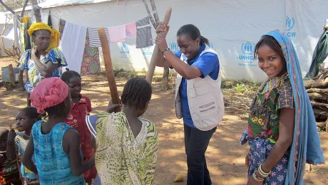 LWF team leader in Cameroon helping women and children prepare food. Photo: LWF Cameroon