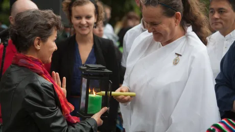 Christiana Figueres, UNFCC Exec. Secretary receiving the light during an Interfaith vigil, with Caroline Richter, LWF and faith members of Brahma Kuaris, LWF/Sean Hawkey