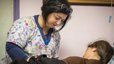 Rihab George, senior nurse in the outpatient unit of the Augusta Victoria Hospital, disconnects a bag of antibiotics from a child patient. The hospital offers specialized treatment to Palestinians which is not available to them elsewhere. Photo: LWF/Albin Hillert