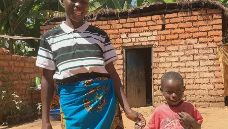 EspÃ©rence manages to get her son, Divin, to stand still just long enough for a photo before he and his friends go back to playing their own version of the World Cup. EspÃ©rence is reaping the benefits of a vegetable garden she planted, with support from the LWF. Photo: LWF/Pablo Lo Moro