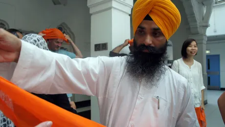 Gurmel Singh from the Sikh Temple in Hong Kong handing out headscarves to participants at the interfaith consultation in Hong Kong. Photo: LWF/I. Benesch 