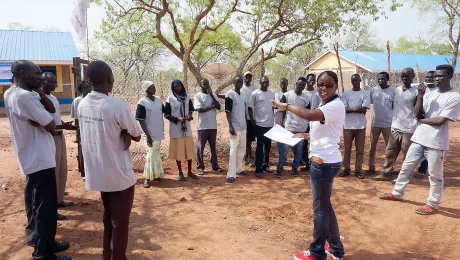 A staff members directs information and communications technology students outside the ICT centre in the Ajuongthok refugee camp where Anne Mwaura works. Photo: LWF/C. Mavenjina