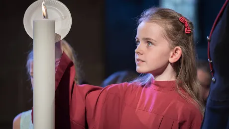 A girl lights a candle at Lund Cathedral, signifying one of the five ecumenical imperatives. Photo: LWF/Albin Hillert