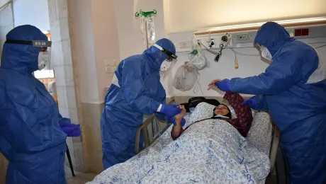 DrÂ  AliÂ Sabateen, whoÂ isÂ head of infectious diseases unit and of the Coronavirus Center, comforts a patient at Augusta Victoria Hospital, Jerusalem. Photo: LWF/AVH/EzdiharÂ Shaheen