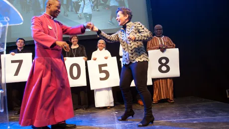 Christiana Figueres, Executive Secretary of the United Nations Framework Convention on Climate Change, dances with Archbishop Thabo Makgoba of South Africa to celebrate some 1.8 million signatures on an interfaith petition for climate justice during the COP21 climate summit in Paris, France. Photo: LWF/R. Rodrick Beiler