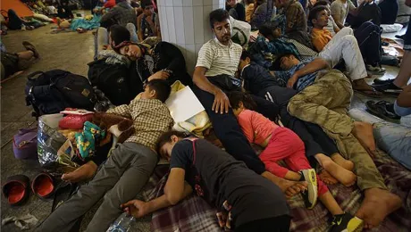 Refugees lie exhausted in a public place in Hungary, en route to northern European countries. Photo:MTI