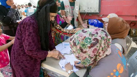 A refugee from Mosul, Iraq, checks her name in order to recieve assistance, at the Dibaga camp, Makhmur, Iraq. Photo: LWF/Seivan M.Salim