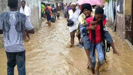 A survivor is carried to safety through a flooded street. Photos: LWF Haiti 