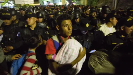 A father carries his baby at the Aguas Calientes border post between Honduras and Guatemala, close to a military roadblock. No undocumented migrant was allowed out of Honduras or into Guatemala, and anyone with an arrest warrant on either side of the border was taken into custody. Photo: LWF/Sean Hawkey