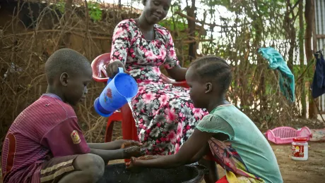 A woman washes her childrenâs hands in Kakuma refugee camp, Kenya. LWF has reinforced hygiene education to prevent a spread of COVID-19 in the camp. Photo: LWF/ P. Omagwa