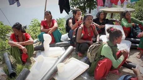 Sita, middle, and neighbours sitting among emergency toilet kits. Photo: Lucia de Vries