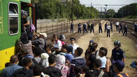 Hungarian police form a cordon as refugees board a train for northern Europe. Photo: MTI