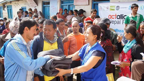 LWF staff offer blankets to earthquake survivors in Lalitpur district. Photo: LWF/C. KÃ¤stner