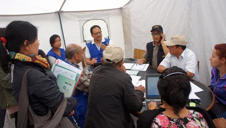 LWF Country Director Nepal, Dr Prabin Manandhar, (center, with blue vest) at a team meeting coordinating the LWF earthquake relief work. Photo: LWF/C. KÃ¤stner 