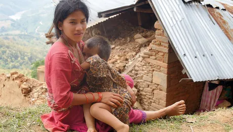 Sapana Roka Sarki, nursing her youngest child in front of her house. She has three children, since their livelihood is gone her husband is looking for work abroad. Photo: LWF/ C. KÃ¤stner