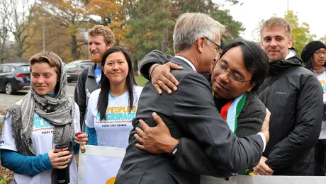 LWF general secretary Rev. Dr Martin Junge greets climate campaigner Yeb SaÃ±o as SaÃ±o and 17 other pilgrims arrive in Geneva on a march from Rome to Paris to push for a new climate deal. Photo: LWF/S. Gallay