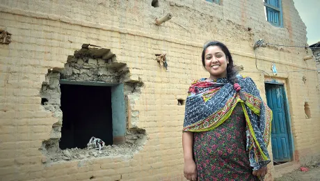 Rosni Paryar, in front of her partially destroyed home. She fear she will remain unemployed because she of the Dalit caste. Photo: LWF/Lucia de Vries