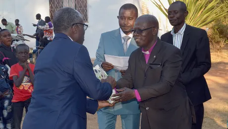 ELCCo Presiding Bishop RenÃ© Mwamba Sumaili offers a gift to Evangelical Lutheran Church in Tanzania General Secretary Brighton Killewa (left). Third from right is ELCCo General Secretary, Gilbert Ilunga Nkasa Talwa. Photo: LWF/Gracia Rubona