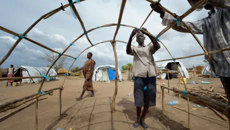 Men in South Sudan reconstruct their house after the village was destroyed in Jonglei. Photo: ACT/ Paul Jeffrey