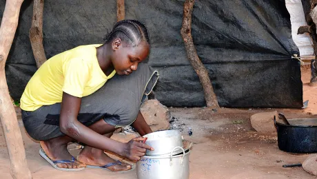 Sudanese refugee Amona Tia prepares the evening meal for her siblings at the Ajuong Thok refugee camp in South Sudan. With help from the LWF, she has resumed schooling. Photo: LWF/A. Kiura