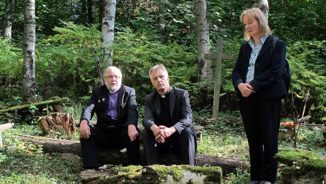 Visiting Keltto cemetery near St Petersburg: (left to right) ELCIR Bishop Arri Kugappi, LWF General Secretary Rev. Martin Junge and Europe Area Secretary Rev. Dr Eva Sibylle Vogel-Mfato at Keltto cemetery, a safe worship space for Ingrian Christians during Communist rule. Photo: Pekka Mikkola/FELM