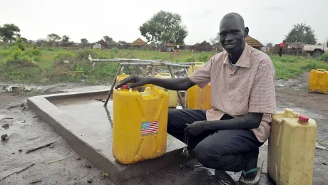 Benjamin, head teacher of Nyumanzi 1 primary school, at the borehole built by LWF with BPRM support next to the school. Photo: LWF/M. Renaux