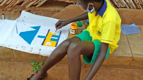 A young refugee paints a house during the retreat. Photo: LWF/ H. Lehto 