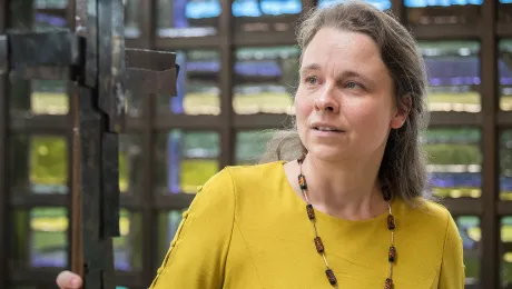 LWF Council member Bettina Westfeld shows a shrapnel cross, moulded from the pieces of shrapnel from bombs dropped over Dresden and Coventry during the Second World War. Photo: LWF/Albin Hillert 