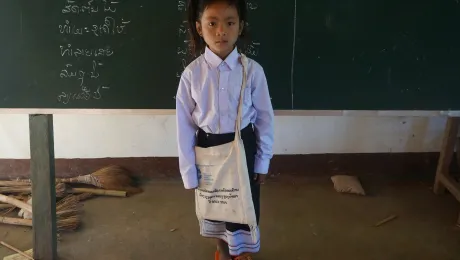 Chanset, an ethnic Khmu girl in northern Laos, with school uniform, books and other items provided by LWF as part of a program to provide access to quality education for girls. Photo: LWF/P. Simayvanh