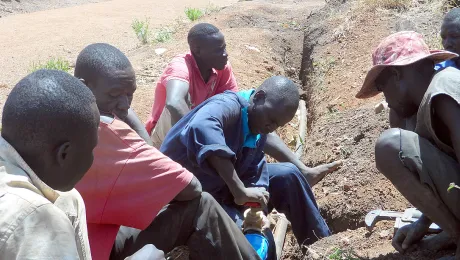 LWF water technicians fix a pipe in Ayilo2 refugee camp, Adjumani district, Uganda. Photo: LWF Uganda