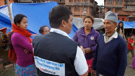 LWF staff member Yadu Lal Shresta (centre), of the LWF Asia emergency hub team, talks to survivors about their living conditions in a camp in Bhaktapur, the worst-affected district of Kathmandu valley. Photo: LWF/C. KÃ¤stner