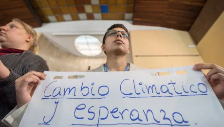 "Cambio Climático y Esperanza" (Climate Change and Hope): LWF delegate Sebastian Ignacio Muñoz Oyarzo from the Evangelical Lutheran Church in Chile holds a sheet of paper presenting a key discussion point from a gathering of faith representatives at an interfaith dialogue and prayer service on the eve of the United Nations Climate Change Conference (COP25) in Madrid, Spain. Photo: LWF/Albin Hillert