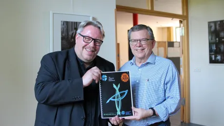 Dr. Uwe Steinmetz, who led the project since 2019, and Prof. Dr Dirk Lange, LWF Assistant General Secretary for Ecumenical Relations, showing the new Global Songbook 2024. Photo: LWF/A. Weyermüller