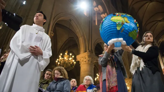 Youth hold symbols of creation during an ecumenical celebration at the Cathredral of Notre Dame de Paris during the COP 21 climate talks taking place in nearby Le Bourget, 3 December 2015 Photo: LWF/Ryan Rodrick Beiler