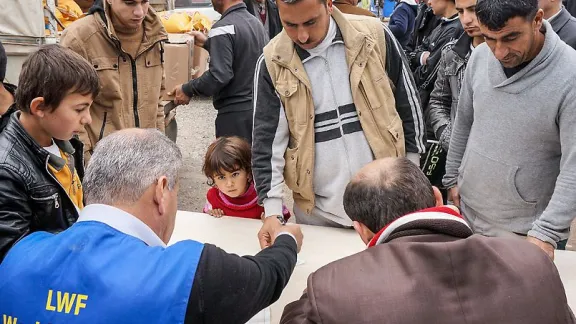 Five year old Vian Shara stands in the crowd at an LWF distribution of food in Northern Iraq. The girl has a kidney condition and needs special treatment. Photo: LWF/ S. Cox