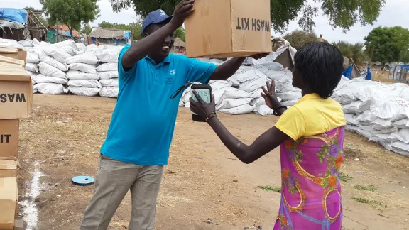 LWF staff provides a displaced woman in Bor with a water, sanitation and health kit. Photo: LWF/South Sudan