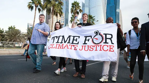 Junge LutheranerInnen nehmen am 1. Dezember mit hunderten weiteren DemonstrantInnen an einem Klima-Marsch in Katar teil, um umfassendere Massnahmen auf dem COP 18-Gipfel zu fordern. © LWB/Sidney Traynham