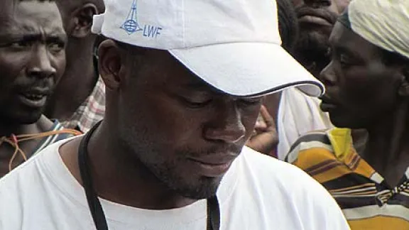 LWF team member Patrick Kalubi examines a list of names at a food distribution center in Goma, DRC. Â© LWF DRC/Fred Otieno