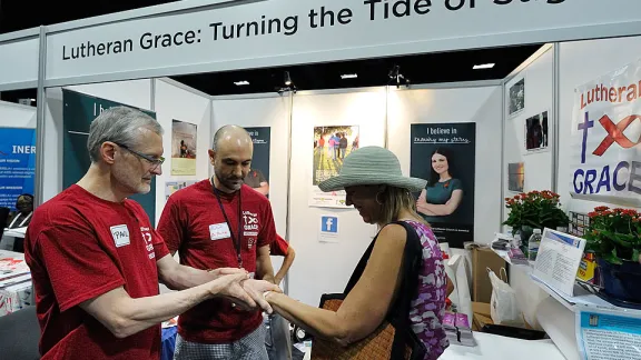 Volunteers offer a visitor a temporary tattoo at the 