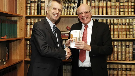 LWF General Secretary Rev. Martin Junge (l) receives a copy of the VELKD publication 