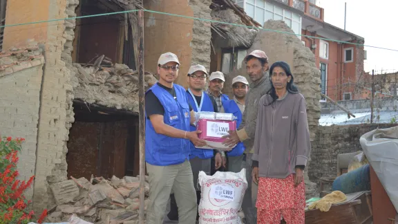 Der LWB übergibt Nothilfe-Material (hier: Fertignahrung) an eine Familie, deren Haus zerstört wurde. Bildnachweis: LWB Nepal